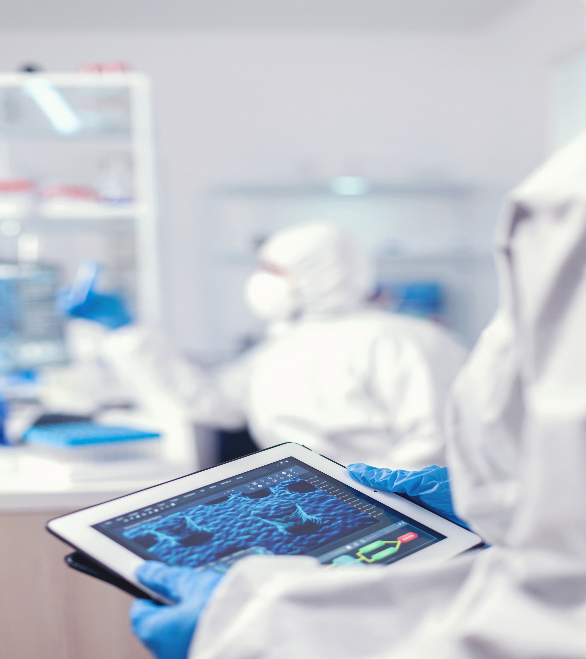 chemist dressed in protection suit for coronavirus holding tablet pc